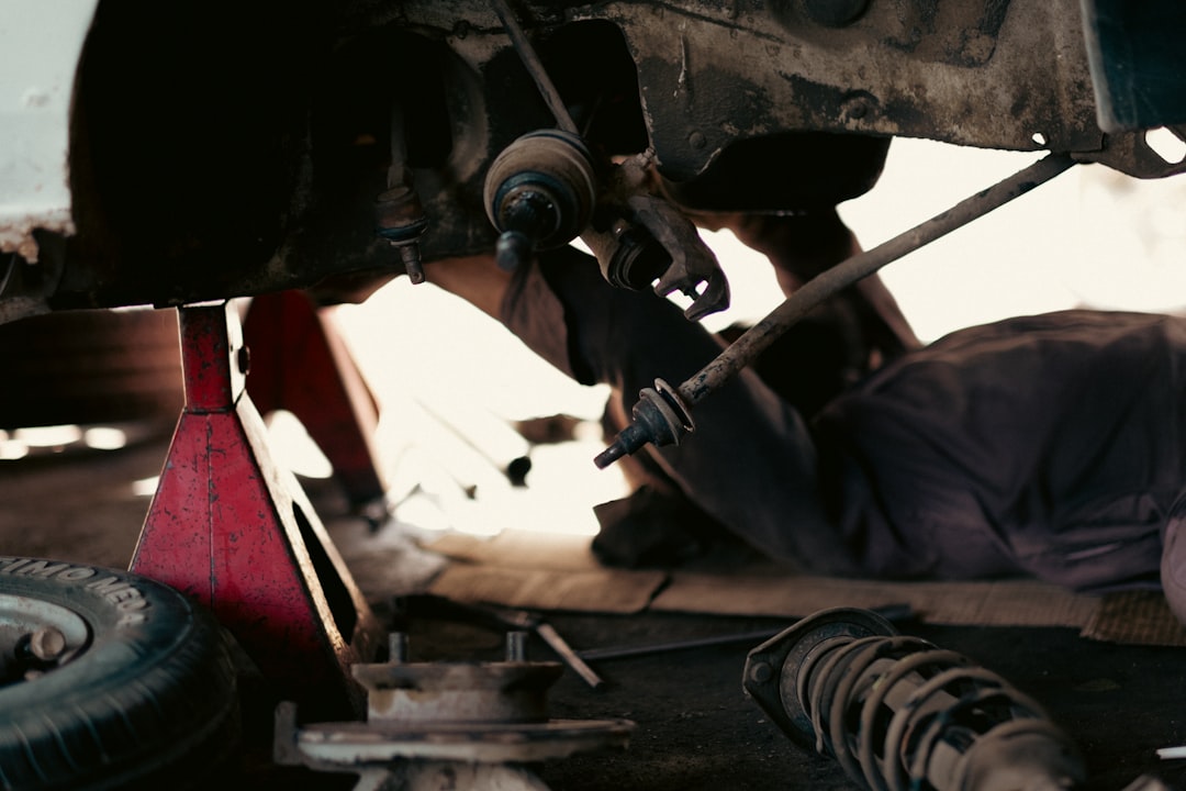 Mobile mechanic working under the hood of a car in a Jackson, Tennessee driveway